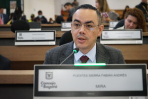Fotografía del concejal Fabián Puentes, del Partido Político MIRA, interviniendo en una sesión del Concejo de Bogotá. Aparece en primer plano con un micrófono, y en el fondo se observan las curules del recinto.