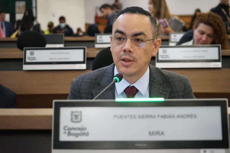 Fotografía del concejal Fabián Puentes, del Partido Político MIRA, interviniendo en una sesión del Concejo de Bogotá. Aparece en primer plano con un micrófono, y en el fondo se observan las curules del recinto.